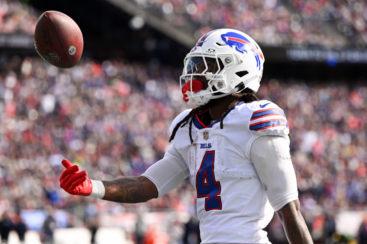 Buffalo Bills running back James Cook (4) tosses the ball after rushes against the New England Patriots during the first half at Gillette Stadium.